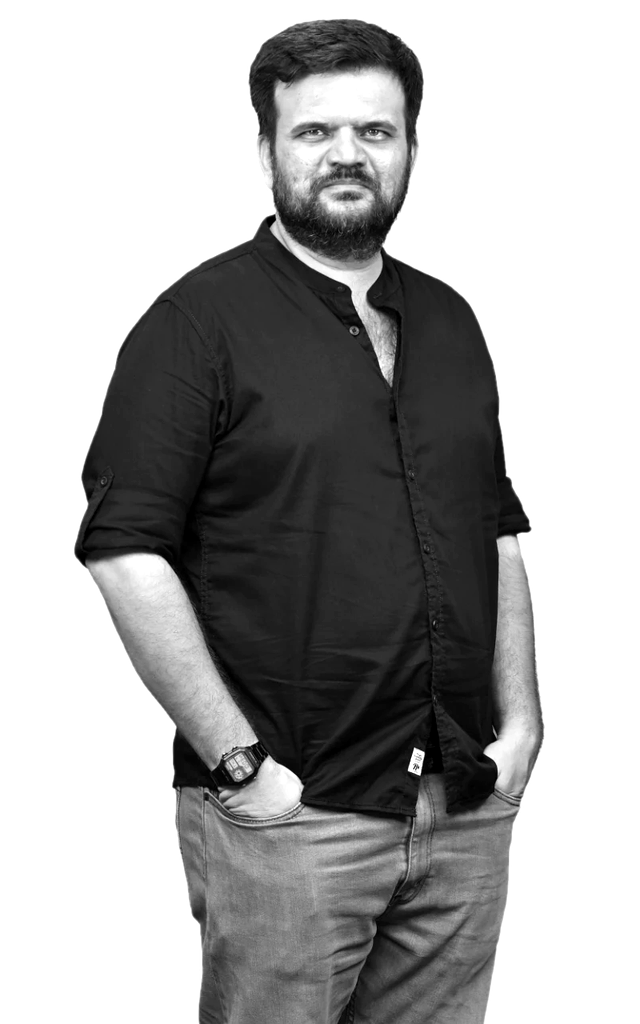 Black-and-white portrait of Brijesh Gokhale in a black shirt, hands in pockets